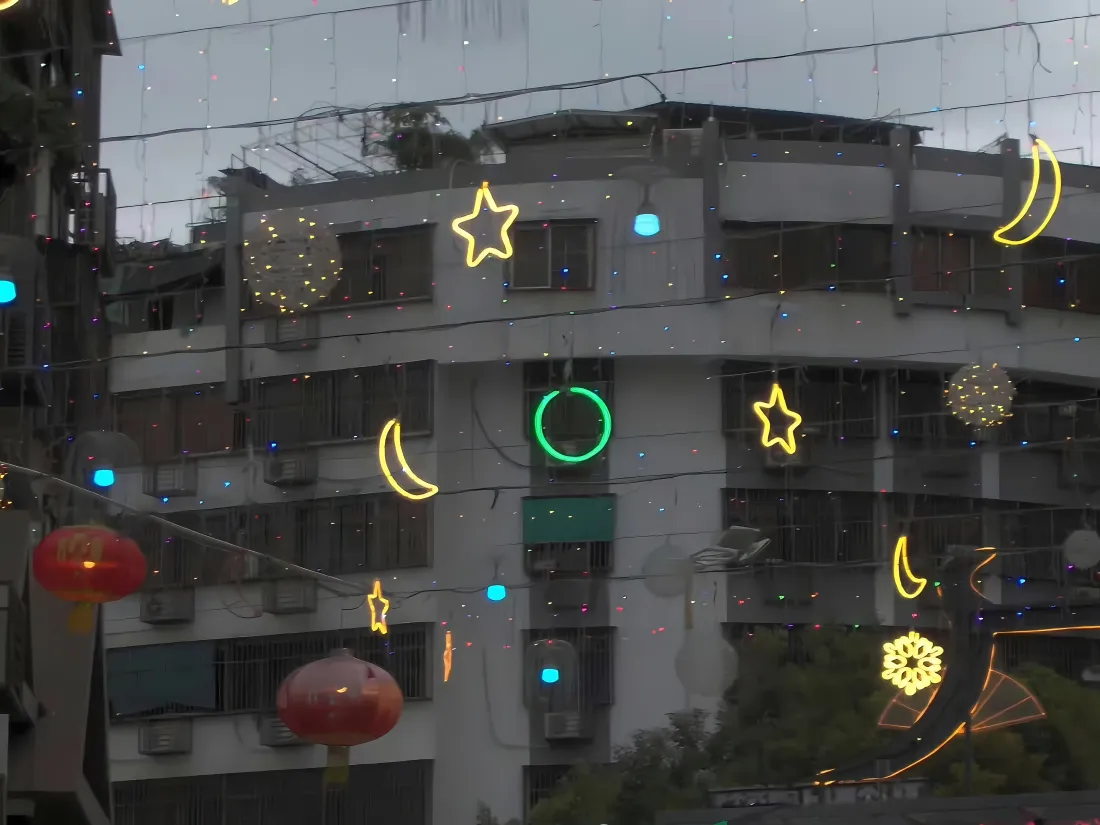 4k节日街景壁纸|居民楼背景图片 - 霓虹灯红灯笼装饰「哲风壁纸」 居民楼前悬挂星月造型霓虹灯与红灯笼,点缀节日灯饰。
