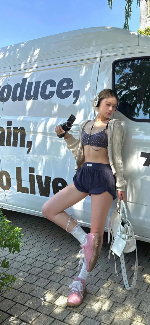 户外晴日，甜酷运动风女生靠白色面包车，手持相机拎白包摆拍