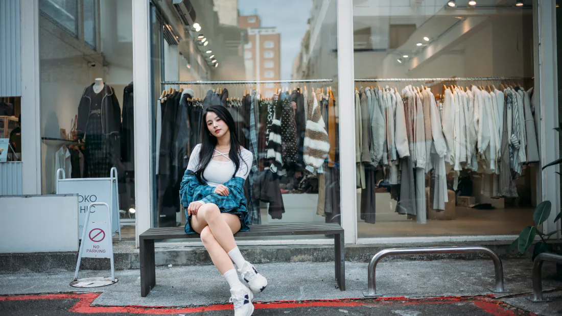 3k壁纸｜街拍穿搭背景图片 - 服装店前坐姿时尚美女「哲风壁纸」