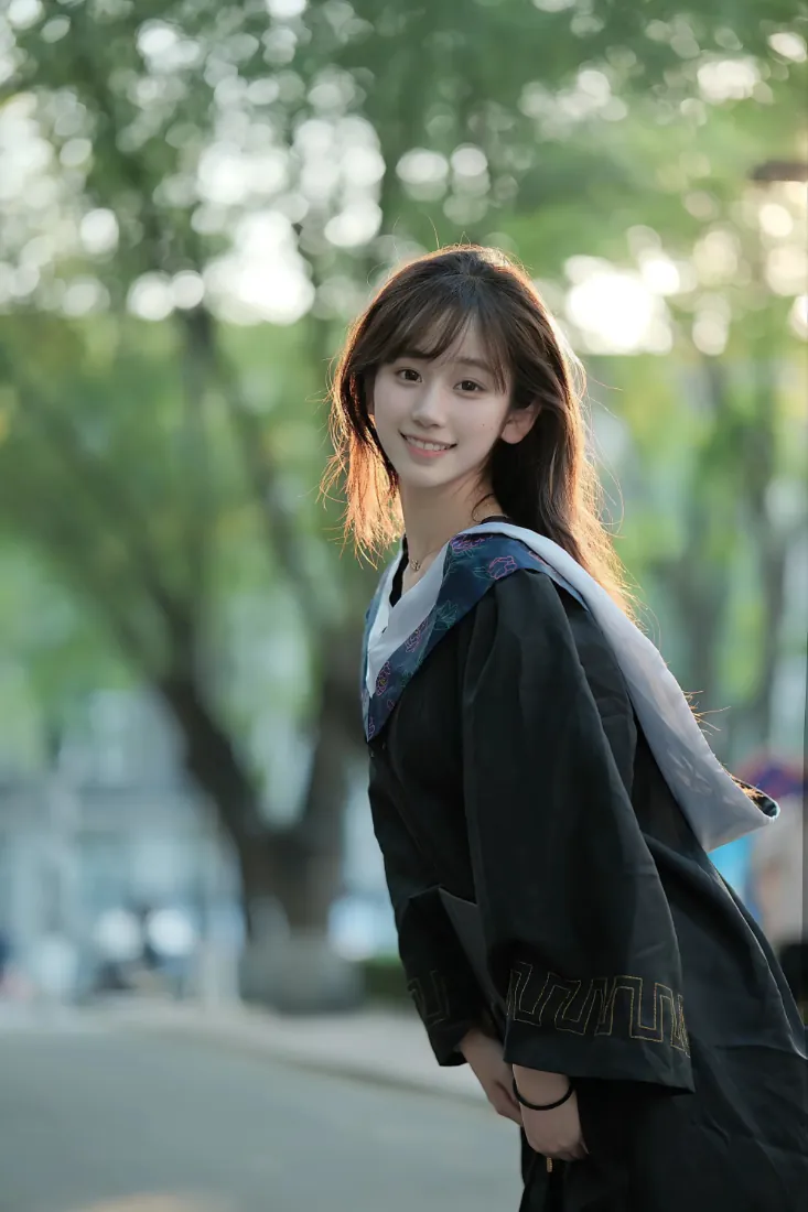 手机壁纸｜学士服毕业女生校园林荫道回头微笑写真背景图片「哲风壁纸」