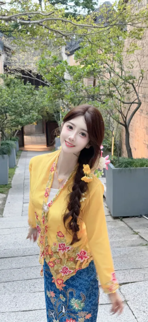 手机壁纸｜背景图片 - 穿黄色娘惹服饰的长发微笑美女户外「哲风壁纸」