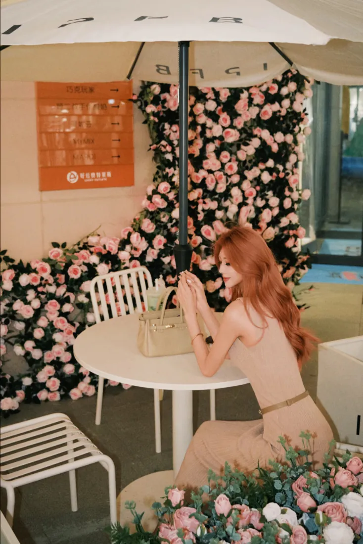 红发美女手机壁纸｜花墙旁休闲桌椅背景图片 - 清新治愈氛围「哲风壁纸」