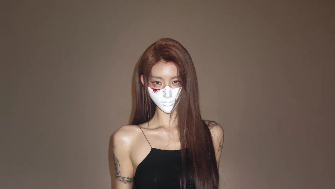 5k美女壁纸|戴白色面具长发吊带美女背景图片 - 简约暗调写真「哲风壁纸」 棕调纯色背景前,戴白色面具的长发纹身美女穿黑色吊带露肩上衣。