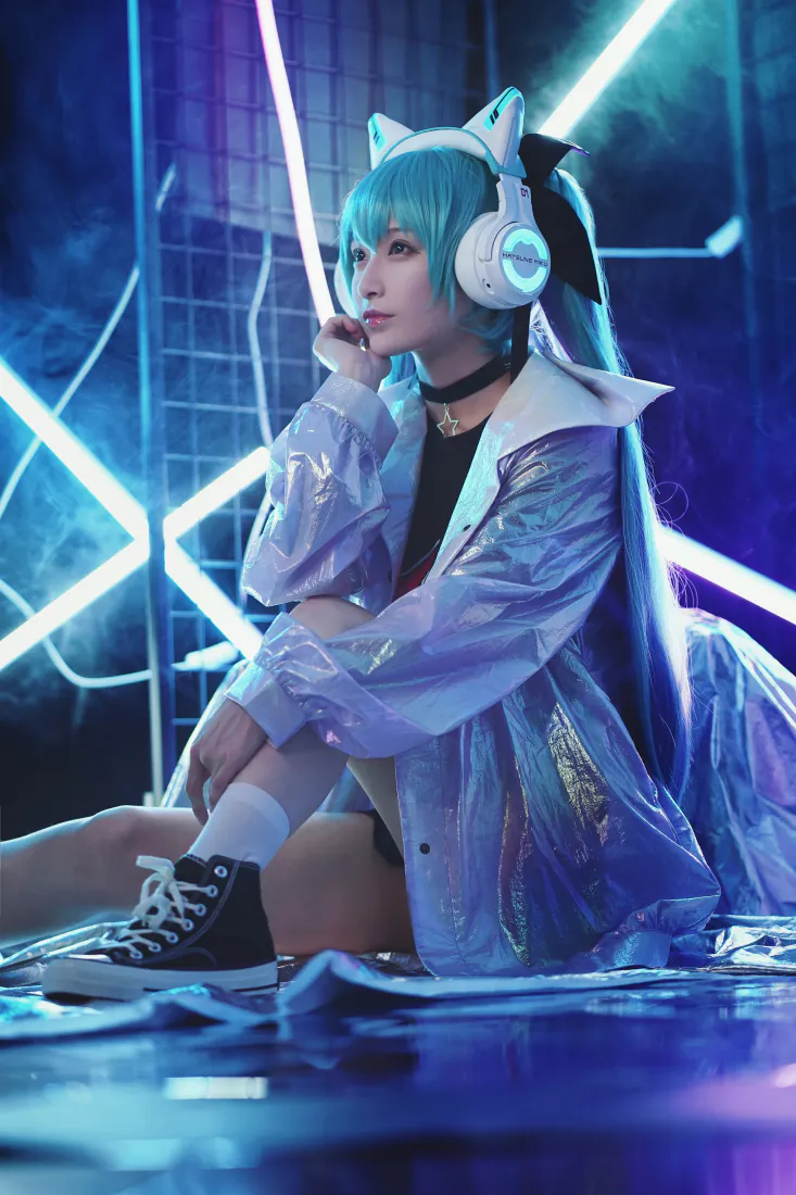 蓝发初音coser戴猫耳耳机，坐于霓虹赛博风室内，穿透明外套配帆布鞋。