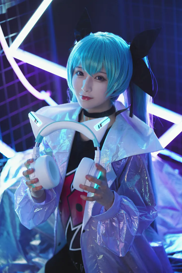 蓝发初音未来coser手持白色耳机，身着镭射外套，身处霓虹灯光室内场景