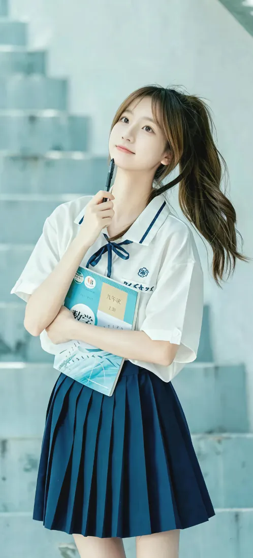 扎马尾的清纯少女身着JK制服，怀抱书本站在虚化的浅色阶梯前。