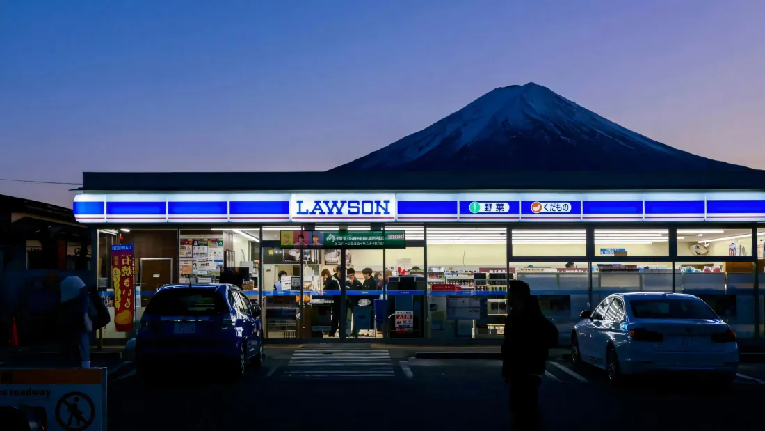 3k富士山壁纸|罗森便利店黄昏街景背景图片 - 静谧日系氛围「哲风壁纸」 暮色下罗森便利店横亘画面,后方露出富士山轮廓,停车场停着轿车。