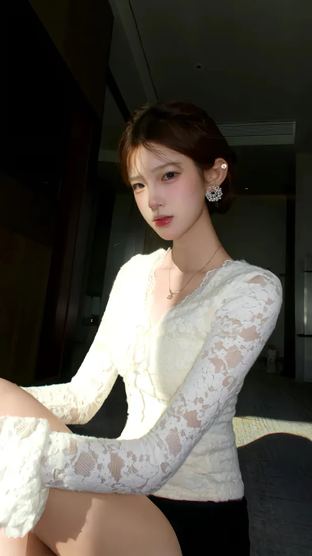 暗调室内环境中，穿白色蕾丝上衣的盘发女生侧身而坐，光线柔和落在身上。