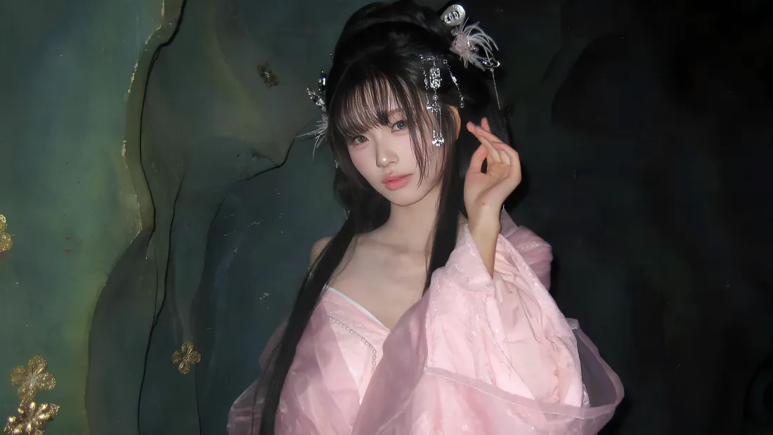 4k古风美女壁纸|粉纱汉服女子背景图片 - 仙气唯美「哲风壁纸」 身着粉色纱质汉服的年轻女子,佩戴银饰发簪,抬手轻触发饰,背景为暗调朦胧的青绿色布景。