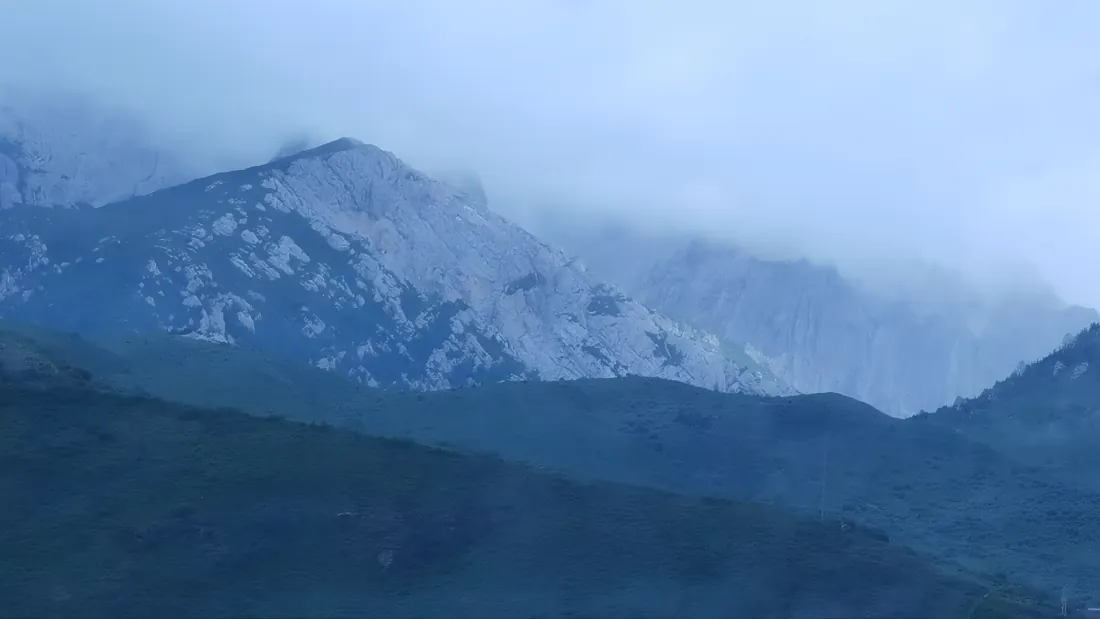 雾霭笼罩的层叠远山，由近及远色调渐浅，朦胧静谧。