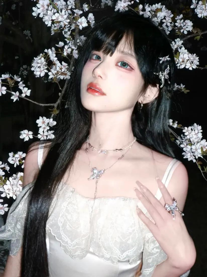 夜晚樱花树下，黑长直齐刘海少女身着白色蕾丝吊带裙，佩戴蝴蝶项链与戒指。