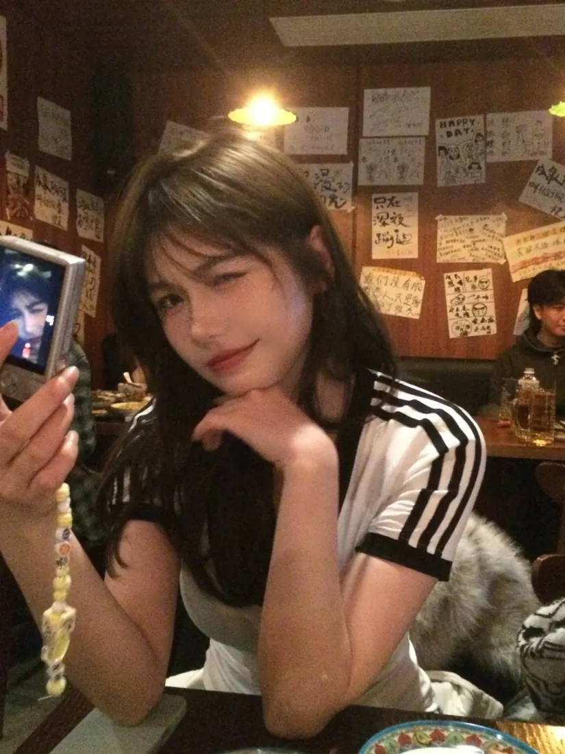 长发少女在暖光复古餐厅内举ccd相机自拍，手托下巴wink。