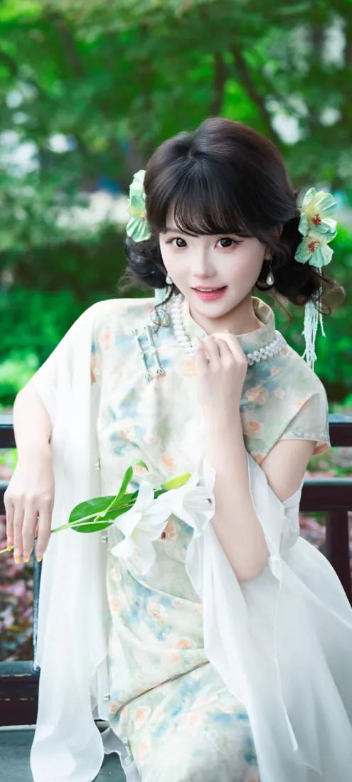 身着浅绿印花旗袍的年轻女子，配白纱披肩与花朵发饰，在绿意园林中温婉浅笑。