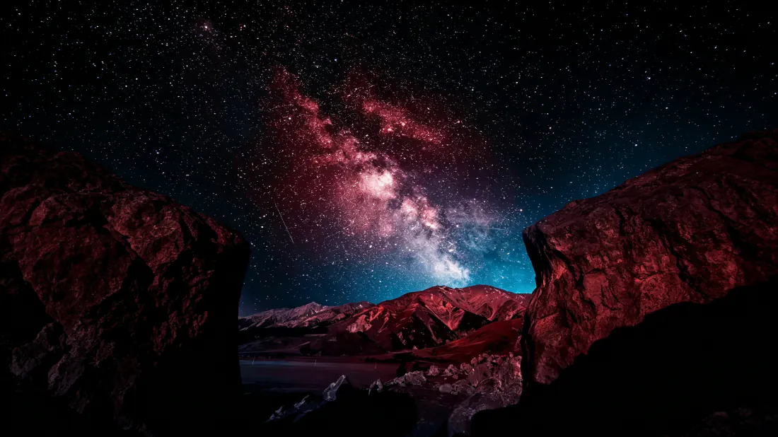 峡谷岩壁间的夜空，粉紫色银河星云横跨天际，繁星密布。